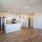 Spacious and well lit kitchen with wood flooring and stainless steel appliances