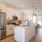 1-Bedroom Homes for Rent in Natomas, CA - Tanzanite - Kitchen with Wood Style Flooring, Stainless Steel Appliances, Quartz Countertops, Breakfast Bar, and Pendant Lights.