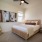 Dog-Friendly Homes in Natomas, CA - Tanzanite - Bedroom with Carpet Flooring, Full-Size Bed, Nightstands with Lamps, Wall Art, and Window.