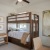 a room with a bunk bed and desk with a chair