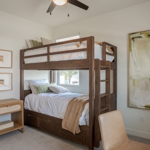 Generous bedroom offerings to fit every family a room with a bunk bed and desk with a chair